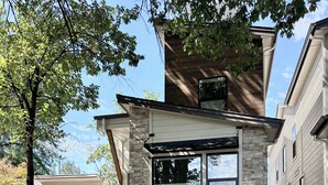 A modern two-story house with a stone facade, large windows, and a well-maintained lawn. - Brand New Home* Dual Master Suites. (Boise)