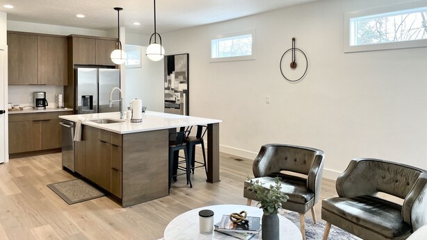 A modern kitchen with a central island, stainless steel appliances, pendant lighting, and a ceiling fan. - Brand New Home* Dual Master Suites. (Boise)