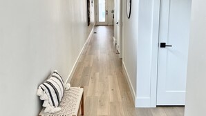 A hallway with a bench, a door, and artwork on the walls. - Brand New Home* Dual Master Suites. (Boise)