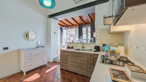 A modern kitchen with a gas stove, white cabinets, and a large window. - Stella Del Lago Pied Dans L'eau in Arona (Arona)