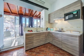 A modern kitchen with wooden cabinets, a built-in microwave, and a view of the outside.