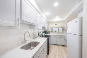 Enjoy cooking in this well-equipped kitchen with a double sink, coffee maker, microwave, and refrigerator.