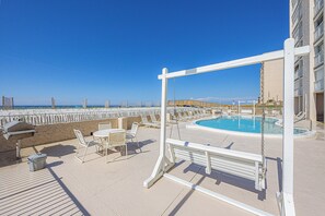 Relax by the ocean with a view from our rooftop pool, surrounded by lounge chairs and a swing set.