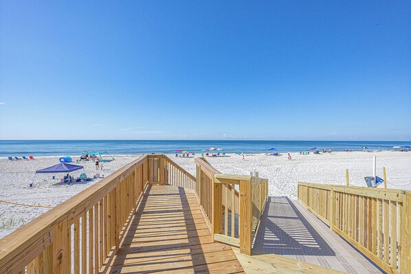 Walk along the boardwalk to the sandy beach, where beachgoers can sunbathe and relax.