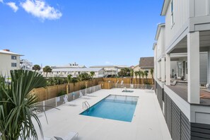 Relax by the pool surrounded by lush palm trees and a modern backdrop.