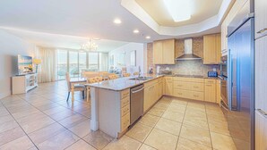 A spacious kitchen with a central island, modern appliances, and a large window providing natural light.