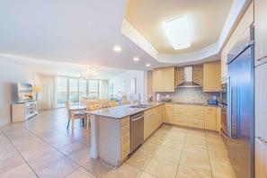 A spacious kitchen with a central island, modern appliances, and a large window providing natural light.
