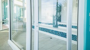 A glass door leading to a pool area with tiled flooring and a clear view of the pool.