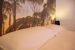 A bed with white linens and a wall mural depicting a forest scene. - Little House - GARDEN - GRAULHET (Graulhet)