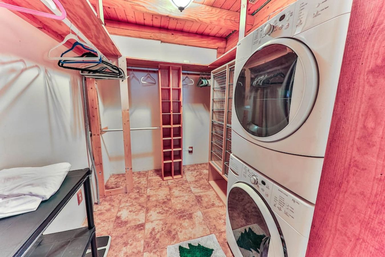 A laundry room with a washing machine, a drying rack, and a clothes drying rack.