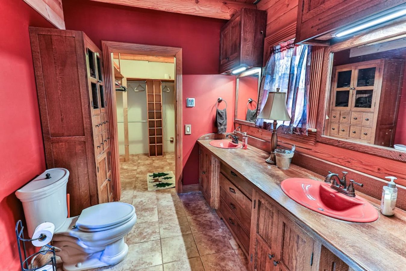 Een kleine badkamer met houten kastjes, een wastafel en een toilet.