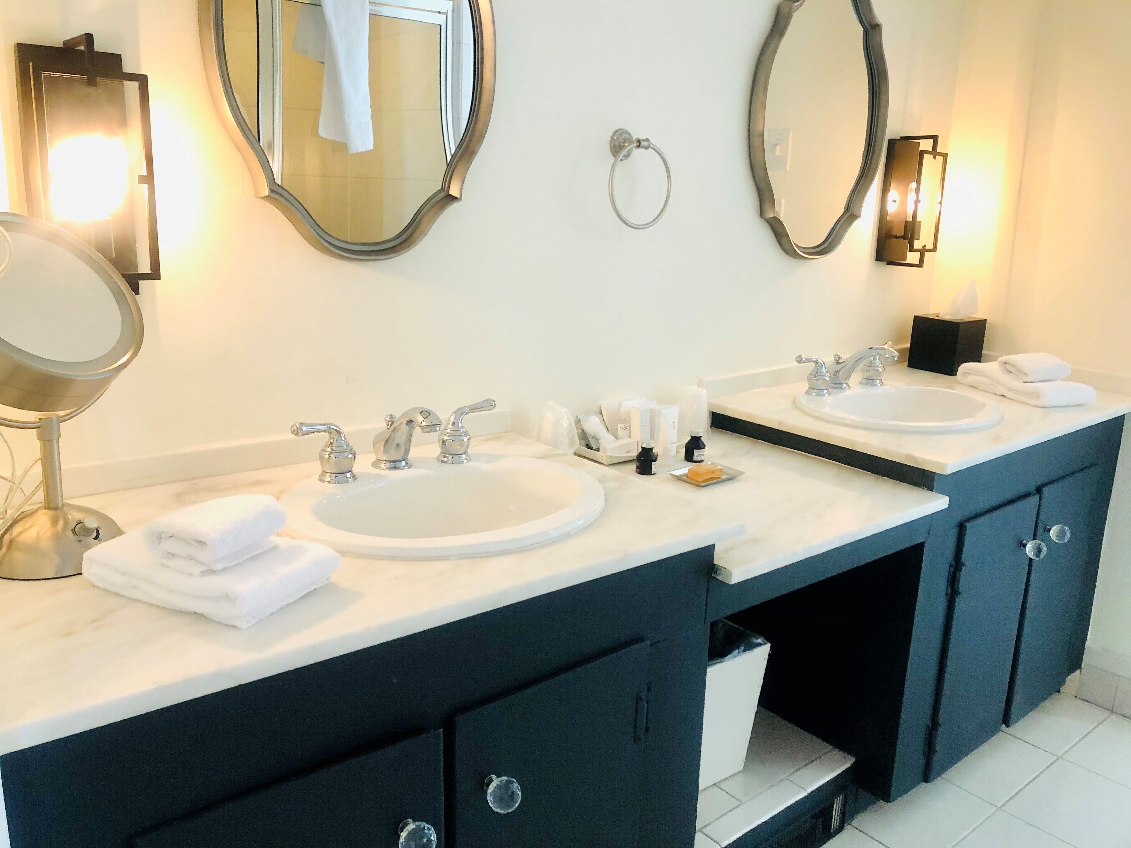 Un baño con dos lavamanos, dos espejos y un mueble de tocador con armarios.