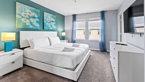 A bedroom with a large bed, two bedside tables, a dresser, a TV, and artwork on the wall. - 5129 Compass Bay 8 guests 4DBR BBQ near Disney (Kissimmee)
