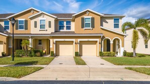 A two-story residential house with a front garage, a covered porch, and a well-maintained lawn. - 5129 Compass Bay 8 guests 4DBR BBQ near Disney (Kissimmee)