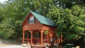 A wooden cabin with a green roof, a porch, and a gravel driveway. - The Hickory Hollow Log Cabin by Garden of Gods in the Shawnee National Forest (Elizabethtown)