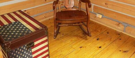 A wooden interior with a wooden chair and a wooden chest with an American flag design.