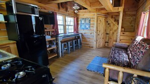 A cabin interior with a kitchen, dining area, and a cozy seating area. - The Hickory Hollow Log Cabin by Garden of Gods in the Shawnee National Forest (Elizabethtown)
