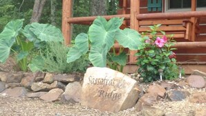 Una piedra con la inscripción "Sassafras Ridge", rodeada de rocas y plantas.