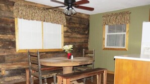 A rustic dining area with a wooden table, chairs, and a ceiling fan. - The Pine Ridge Home by Garden of the Gods in the Shawnee National Forest (Herod)