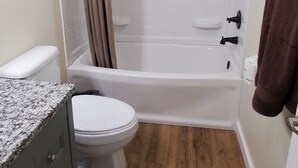 A bathroom with a toilet, a sink, a bathtub, and a shower curtain.