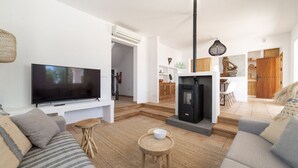 Een moderne woonkamer met een flatscreen televisie, een bank, een salontafel en een open haard.