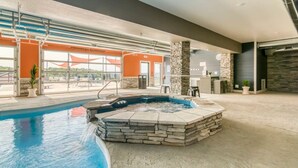 Piscina com hidromassagem, pilares de pedra e vista para o exterior.