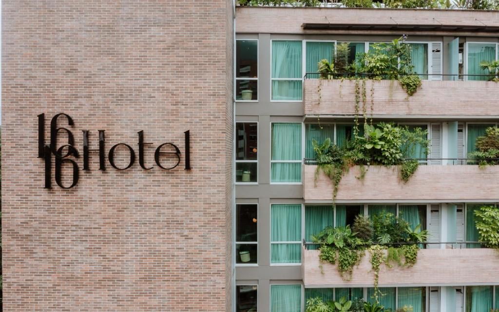 A hotel sign with the name 'Hotel' on a brick wall.