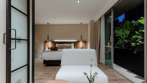 A modern bedroom with a bed, bedside table, and a view of greenery outside. - 1616 HOTEL  (Medellín)