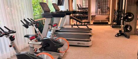 A gym with treadmills, stationary bikes, and weight machines.