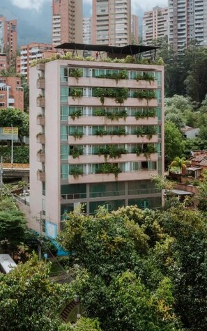 A multi-story building with balconies, surrounded by greenery. - 1616 HOTEL  (Medellín)
