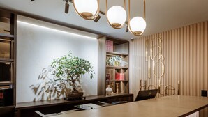 A modern kitchen with a wooden countertop, pendant lighting, and a potted plant. - 1616 HOTEL  (Medellín)