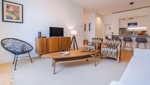 Een moderne woonkamer met een houten eettafel, een zwarte stoel en een bank.