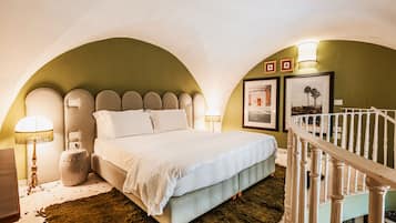 Un dormitorio con una cama grande, una mesita de noche, una lámpara y una escalera.