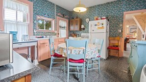 Une cuisine équipée d’une table à manger, de chaises, d’un réfrigérateur et d’un évier.
