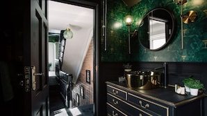 A dark-themed bathroom with a vanity, a mirror, and a green marble wall. - Stylish Designer 4-Bed Home in the Heart of Belfast (Belfast)