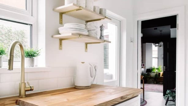 A modern kitchen with a wooden countertop, a gold faucet, and white shelves above the sink. - Stylish Designer 4-Bed Home in the Heart of Belfast (Belfast)