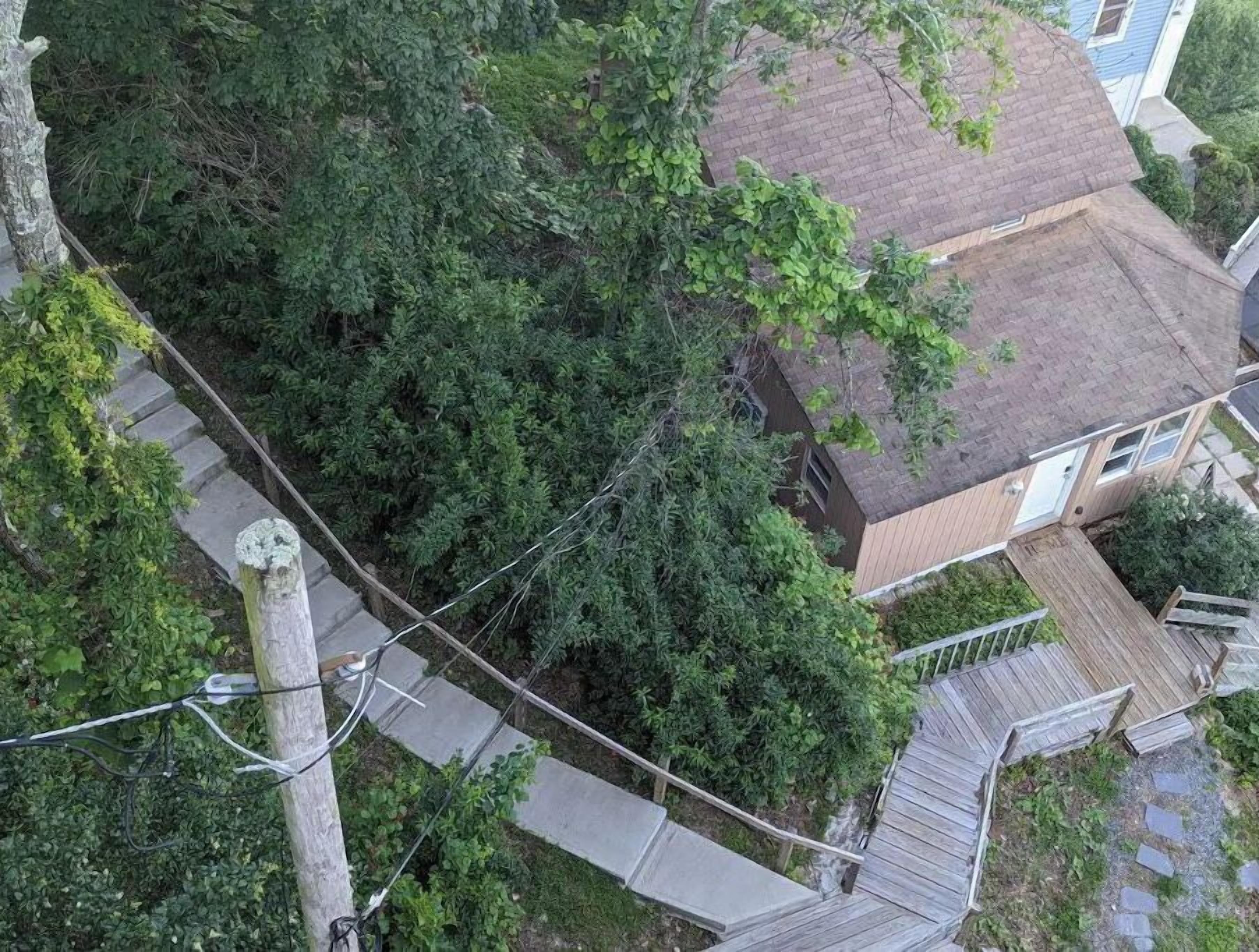 Un quartier résidentiel comprenant une maison, une terrasse en bois et un escalier menant à la maison.