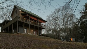 A cabin with a balcony, a fire pit, and outdoor seating. - Wine Country Lake Escape-Fishing and Hot tub (Cleveland)
