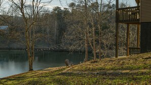 A lakeside view with a wooden deck and chairs overlooking the water. - Wine Country Lake Escape-Fishing and Hot tub (Cleveland)