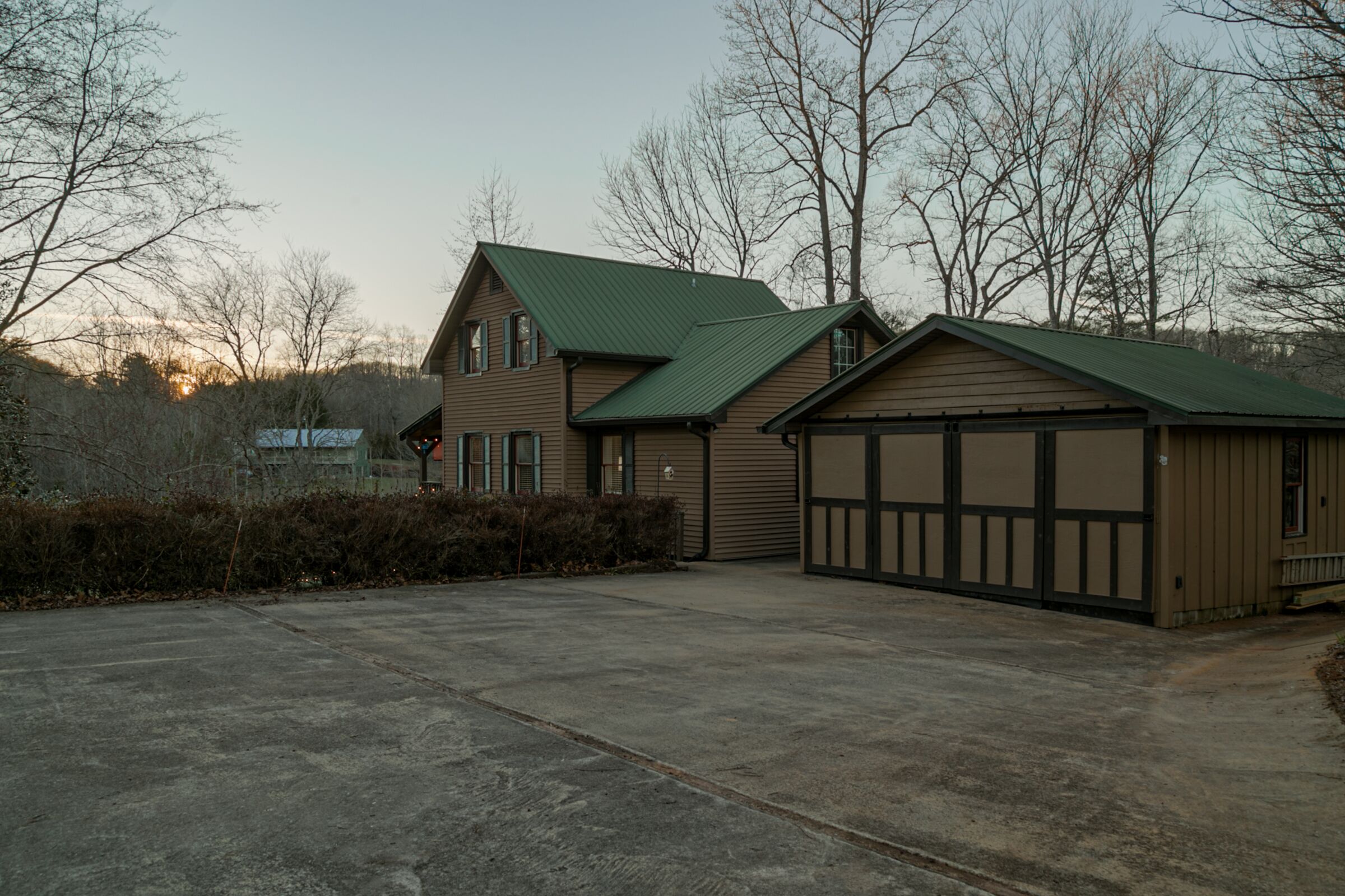 A two-story house with a green roof and a garage.
