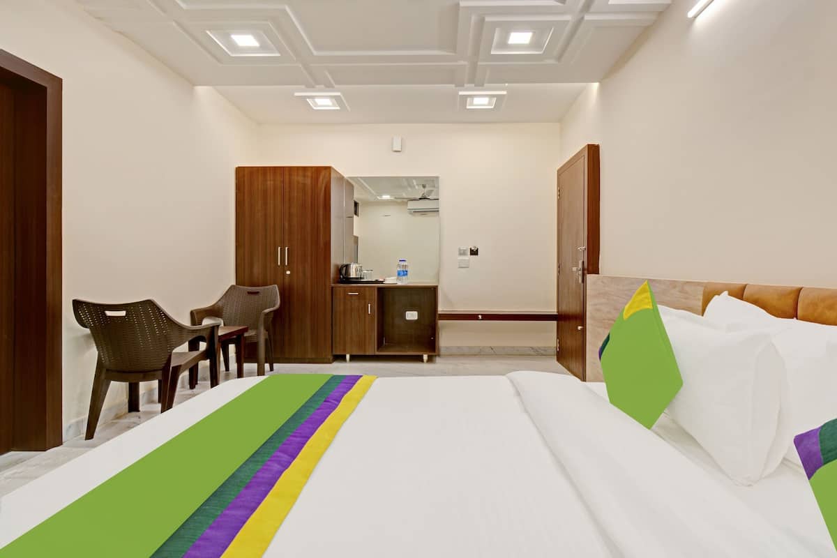A hotel room with a bed, a desk, a chair, and a wardrobe.