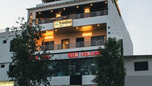 A multi-story building with a sign for 'treebo trend' and another sign with text in a non-Latin script. - Treebo Paras Raj Near City Palace (Udaipur)