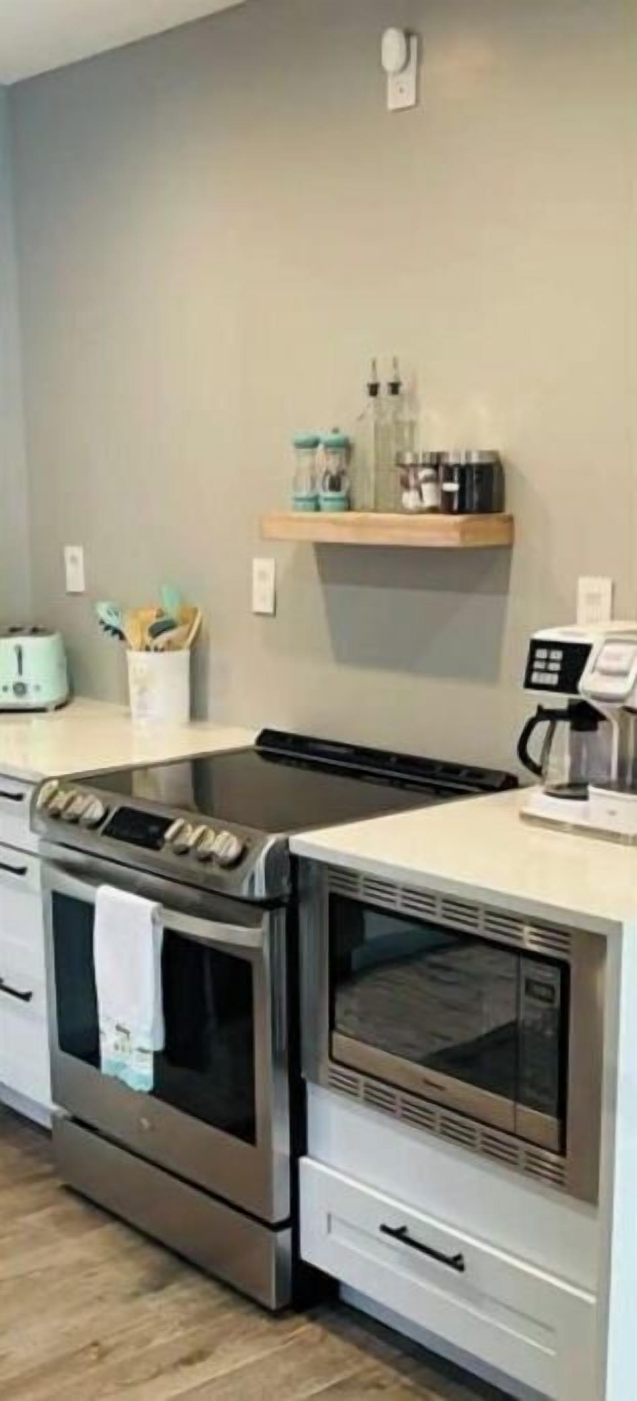 Eine Küche mit zwei Edelstahl-Backöfen, einer Mikrowelle und einer Kaffeemaschine auf der Arbeitsfläche.