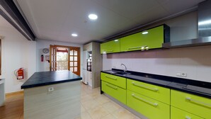 A modern kitchen with green cabinets, a black countertop, and a stainless steel range hood. - Villa Raphael 8 people with pool  (Alcúdia)