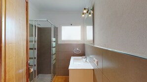 A bathroom with a glass shower enclosure, a white sink, and a mirror with lights. - Villa Raphael 8 people with pool  (Alcúdia)