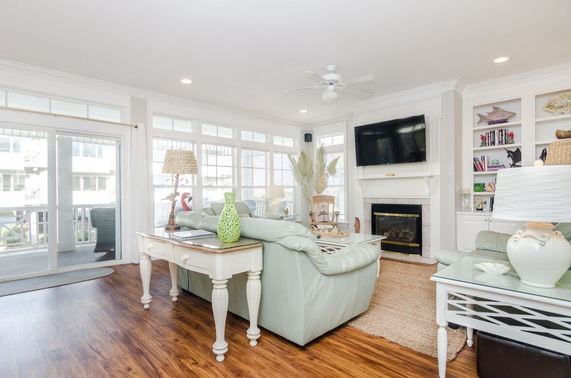 A spacious living room with a light green sofa, a white coffee table, and a fireplace.