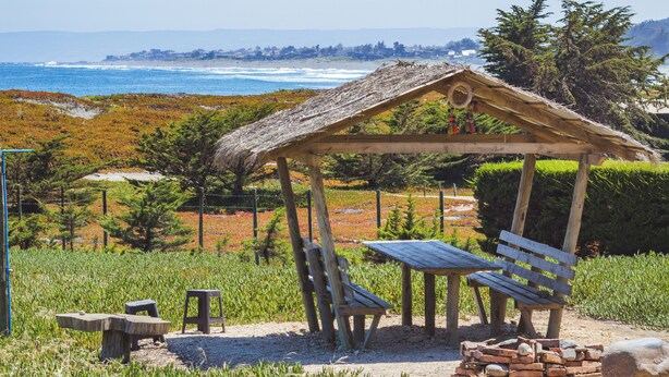 A wooden gazebo with benches and a table, overlooking a beach and ocean. - Beautiful House, Wave/Surf Steps. Point of Wolves (pichilemu)