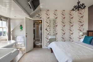 Ett hotellrum med en stor säng, ett badkar, en dusch och utsikt över staden.