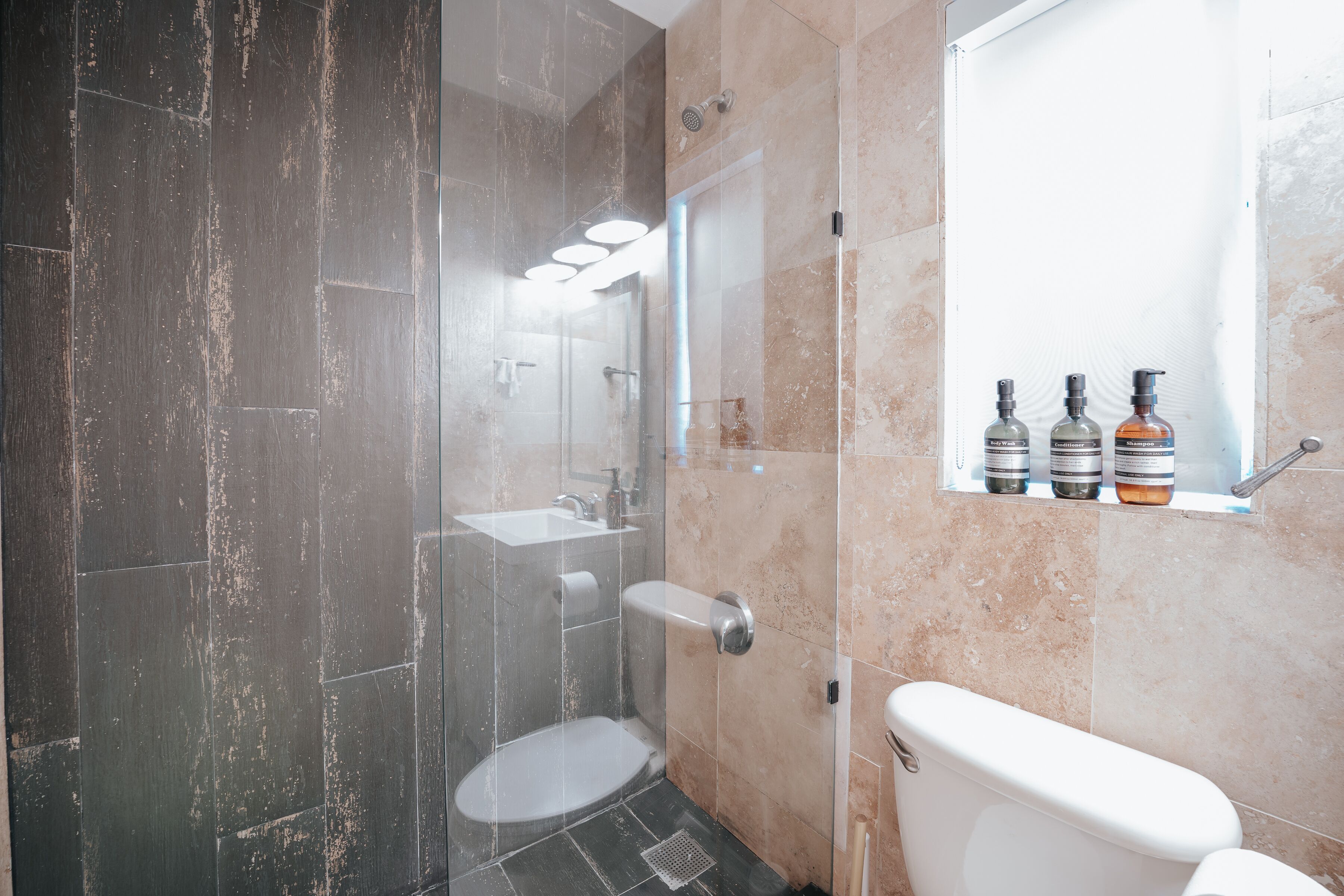Un baño moderno con ducha de vidrio, inodoro y lavamanos.