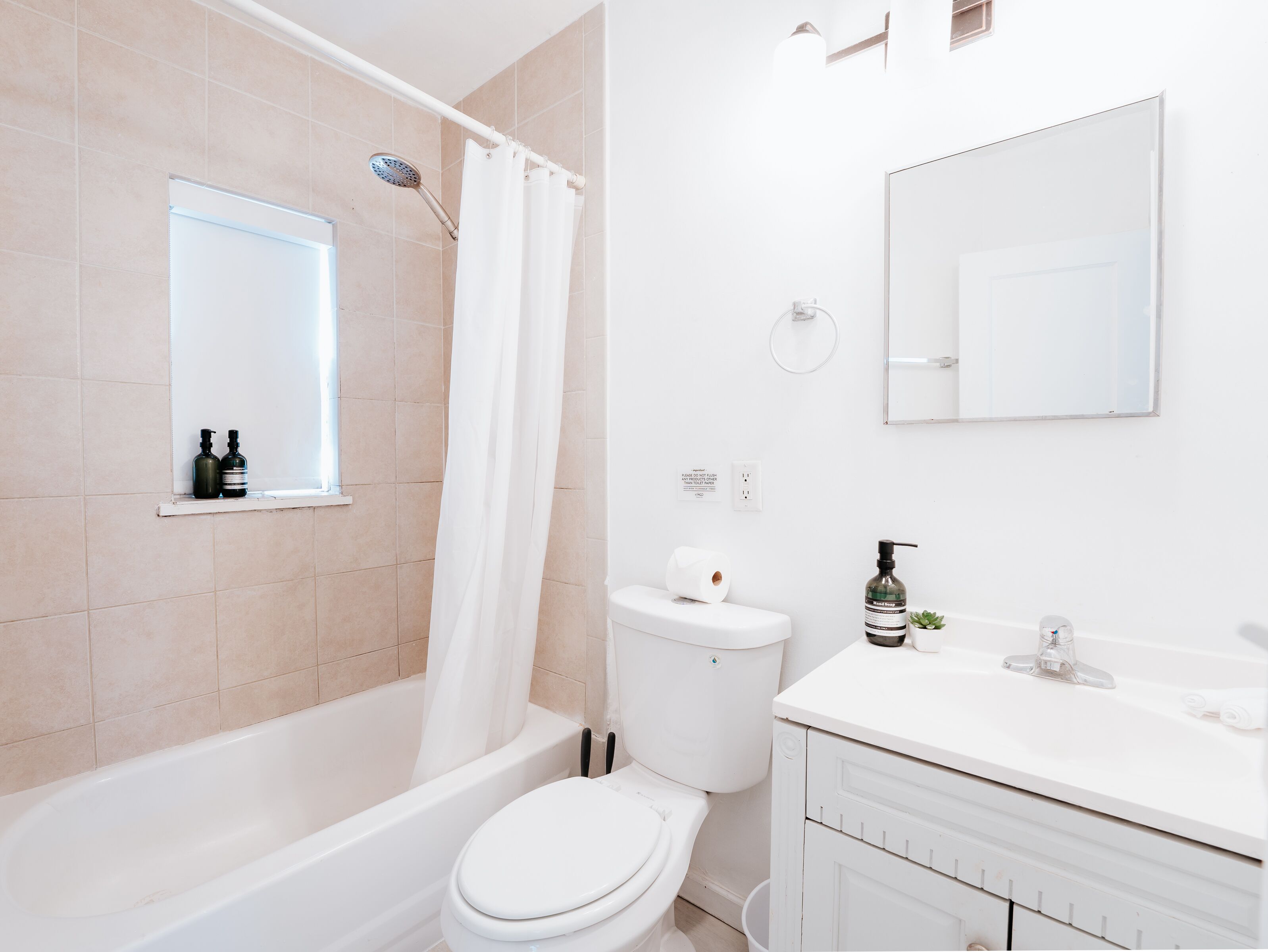 A modern bathroom with a bathtub, toilet, and a sink area.